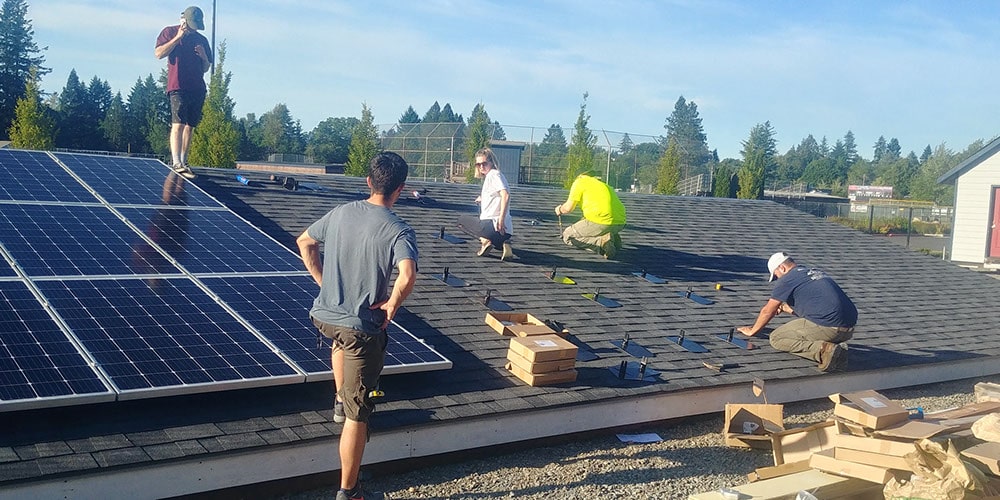 Students on demo roof installing solar panels at Clackamas Community College