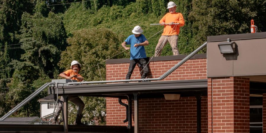 The Secure Futures team works installing solar panels on the roof of St Paul elementary school in Virginia.
