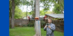 Flying drone. Tree and man in background.