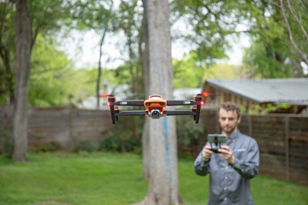 Flying drone. Man and tree in background.