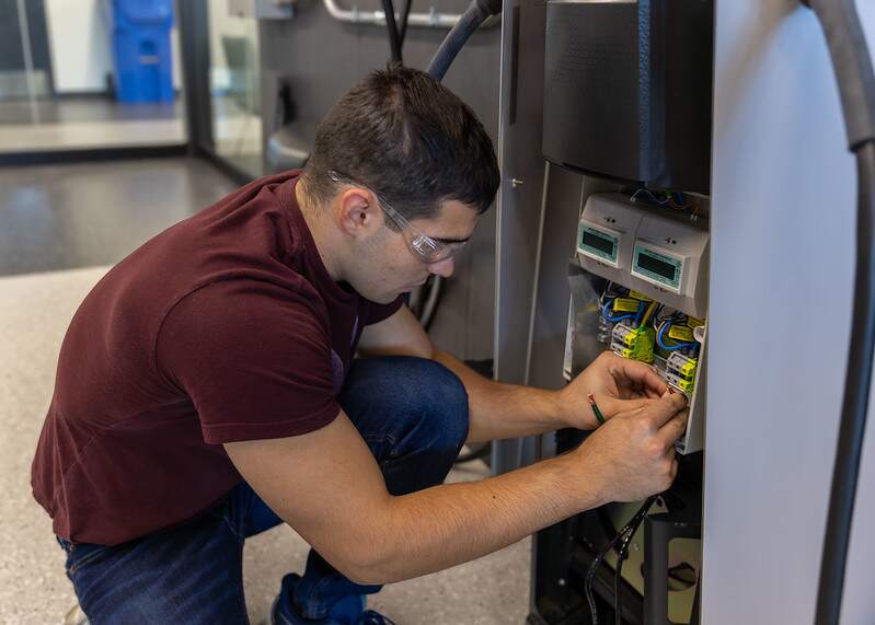 Student inspecting exposed conductors for missing strands or bent strands before termination.