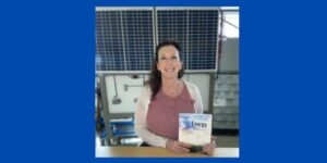 Dr. Jennifer Clemons CREATE Co-PI with solar panels and energy textbook.