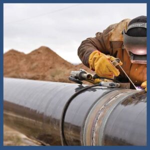 Technician welding on oil pipeline