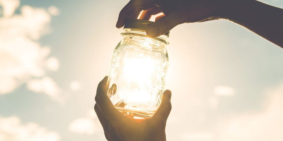 Sunshine, clouds, mason jar and hands.