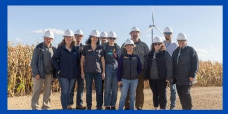 Energy Educators in field with turbine in background